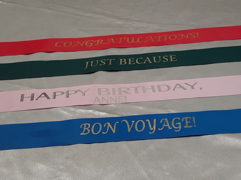 photo of several ribbons printed with messages like Congratulations and Bon Voyage.