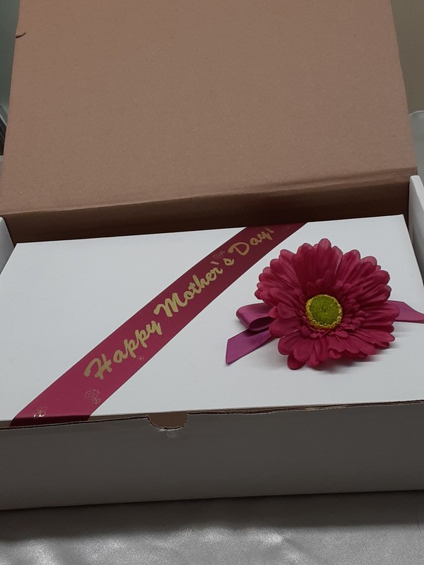 photo of gift box with Mother's Day banner and floral decoration tucked into shipping box